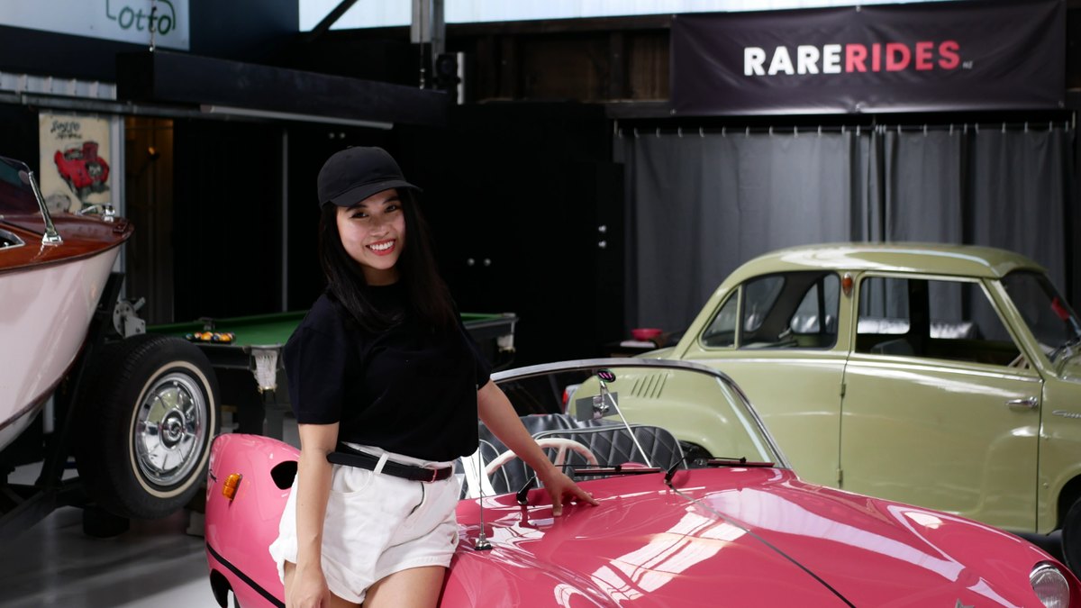 Yen beside the pink Goggomobil Dart in the workshop